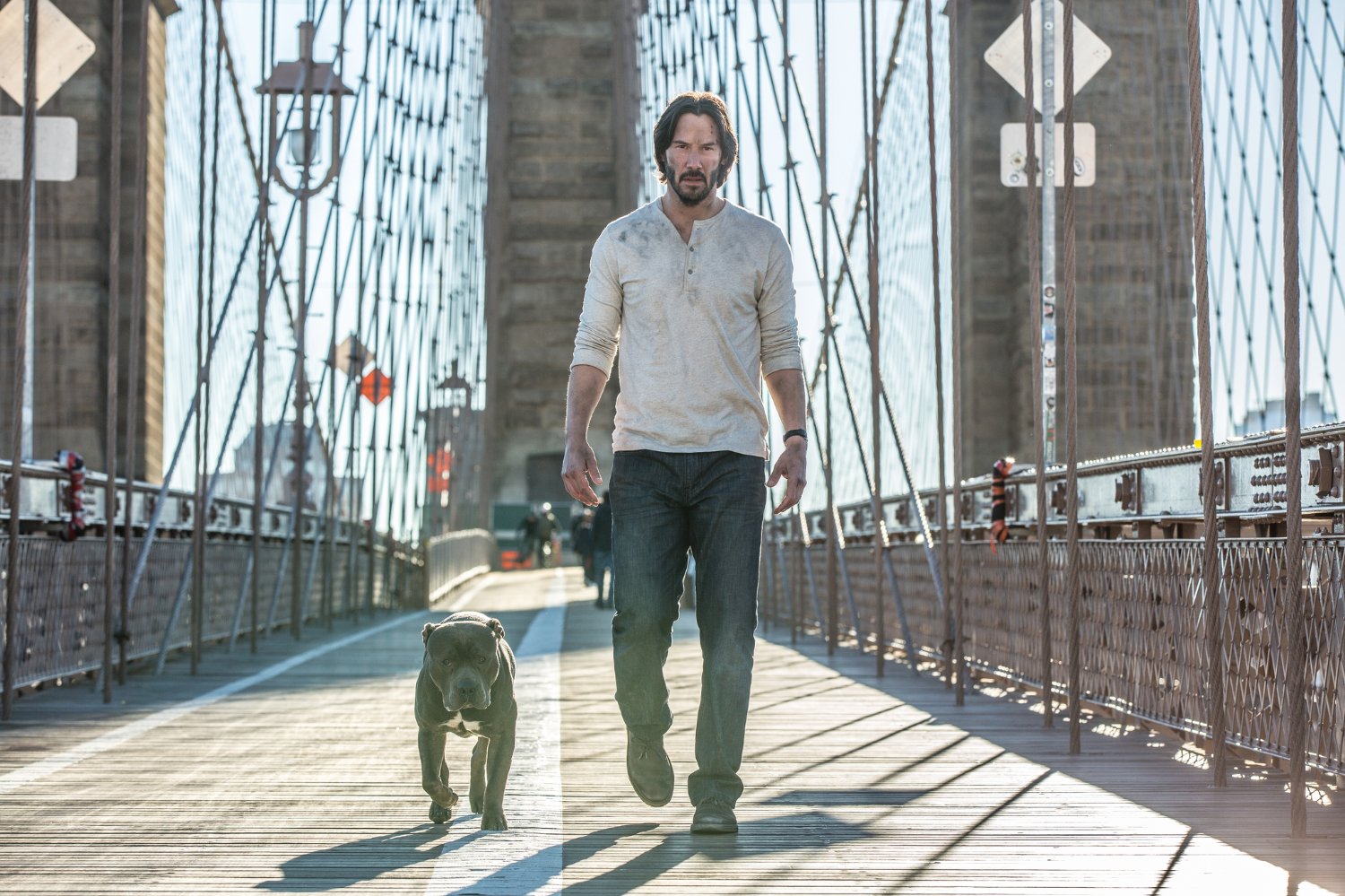 John Wick with pitbull walking Brooklyn bridge