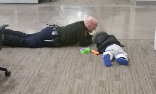 Image of Cop Playing on the Floor with Lost Toddler Goes Viral facebook