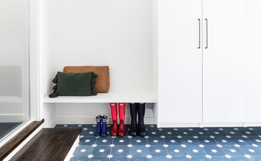 Mudroom bench built into a wall with shoe cubbies underneath and coat hooks above