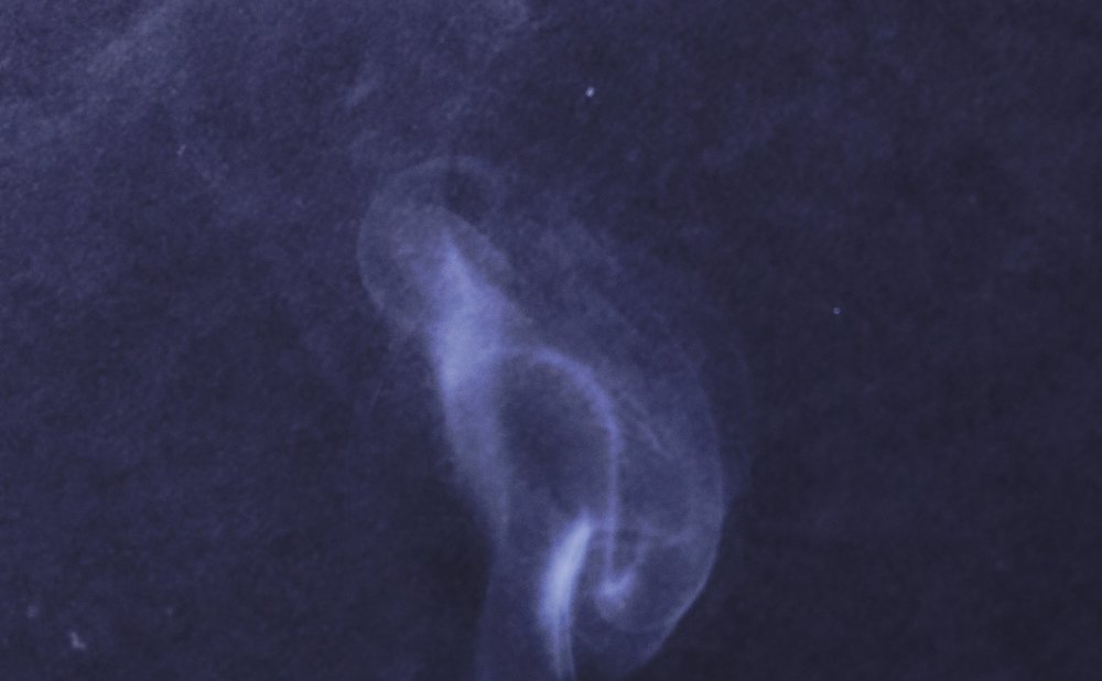 Smoke from an incense stick bending near a door frame to find drafts