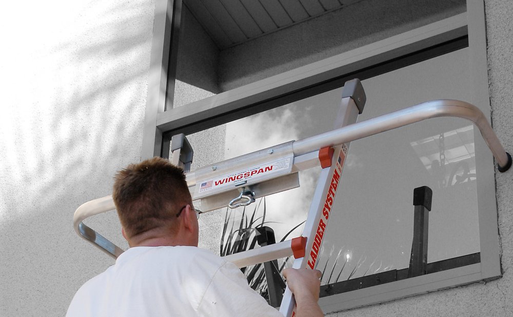 Extension ladder with a standoff holding it off the wall for gutter cleaning safety