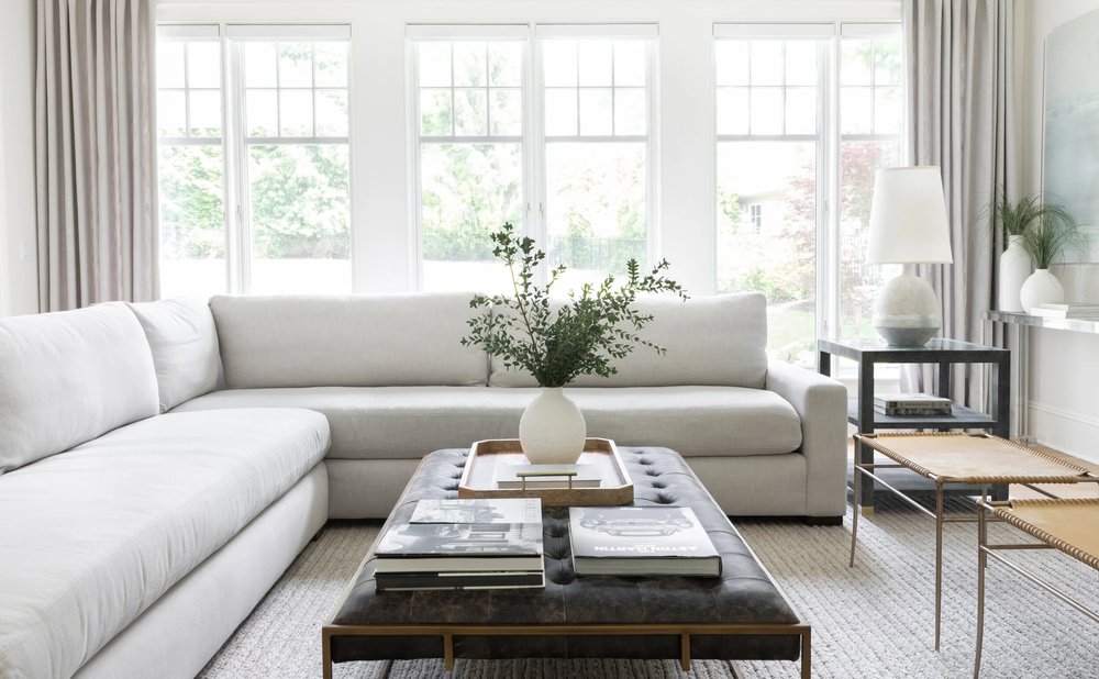 Large woven area rug anchoring a white sectional and coffee table