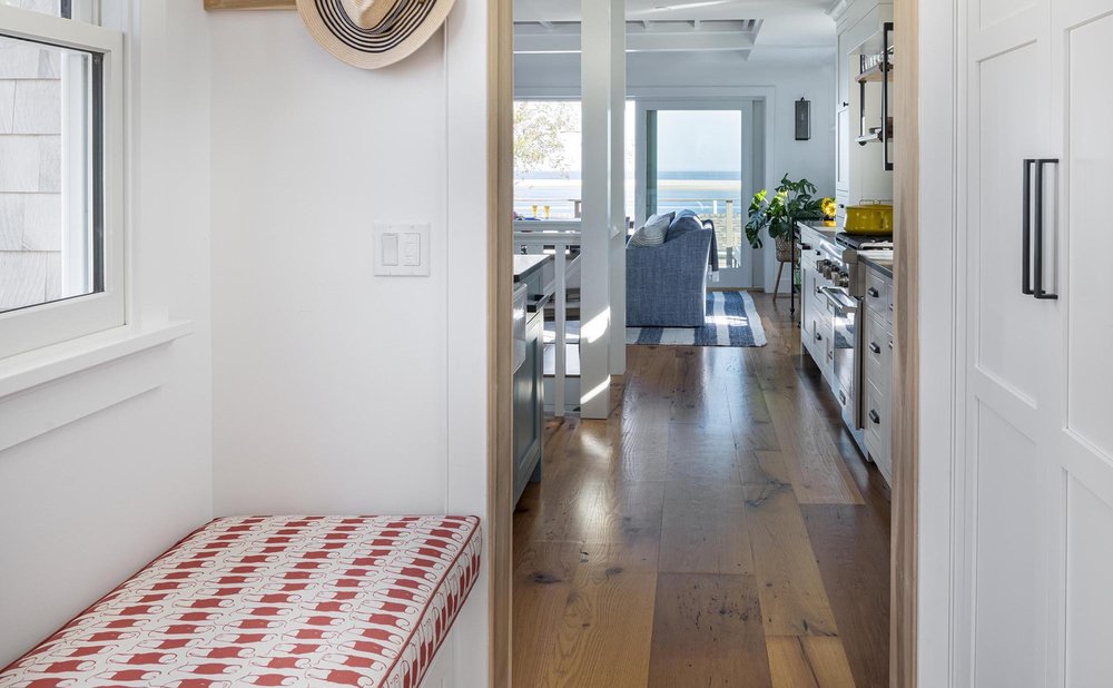 Narrow back-door hallway mudroom with a slim wall-mounted bench and hooks