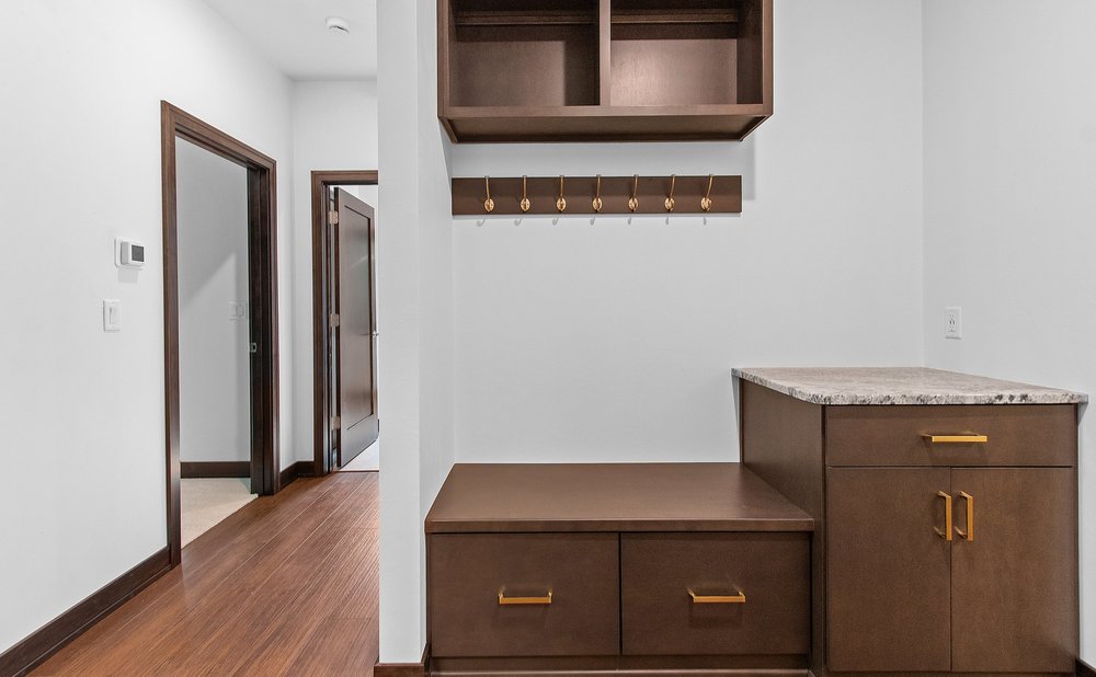 Garage-entry mudroom with a countertop drop zone, cabinets and a bench