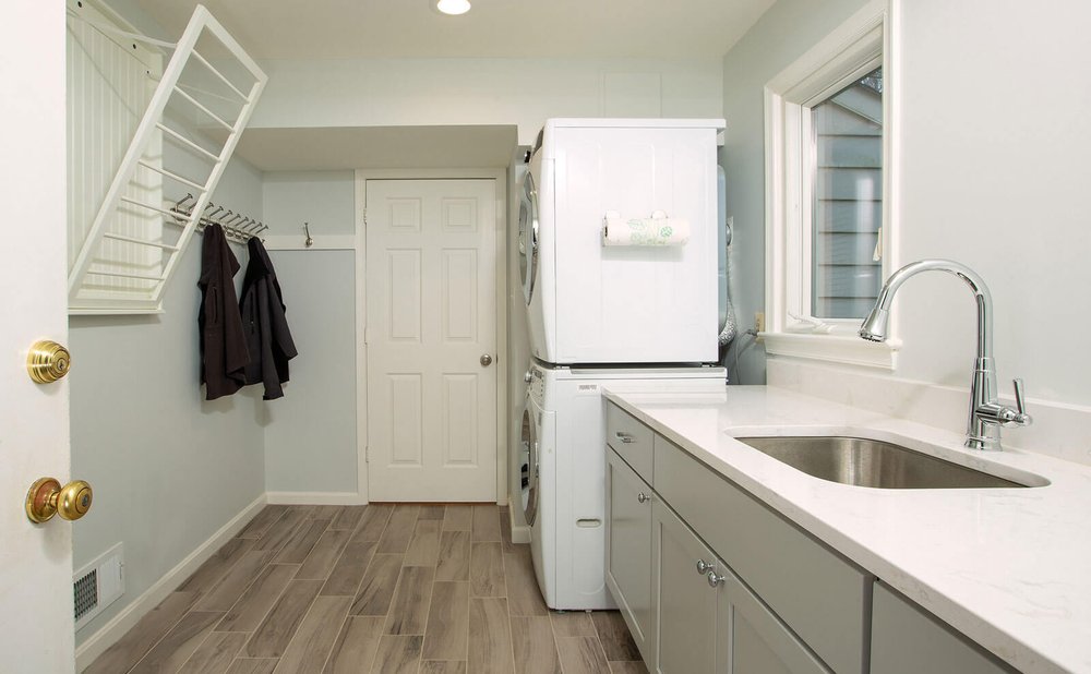 Mudroom and laundry combo with front-load washer and dryer, folding counter and coat hooks