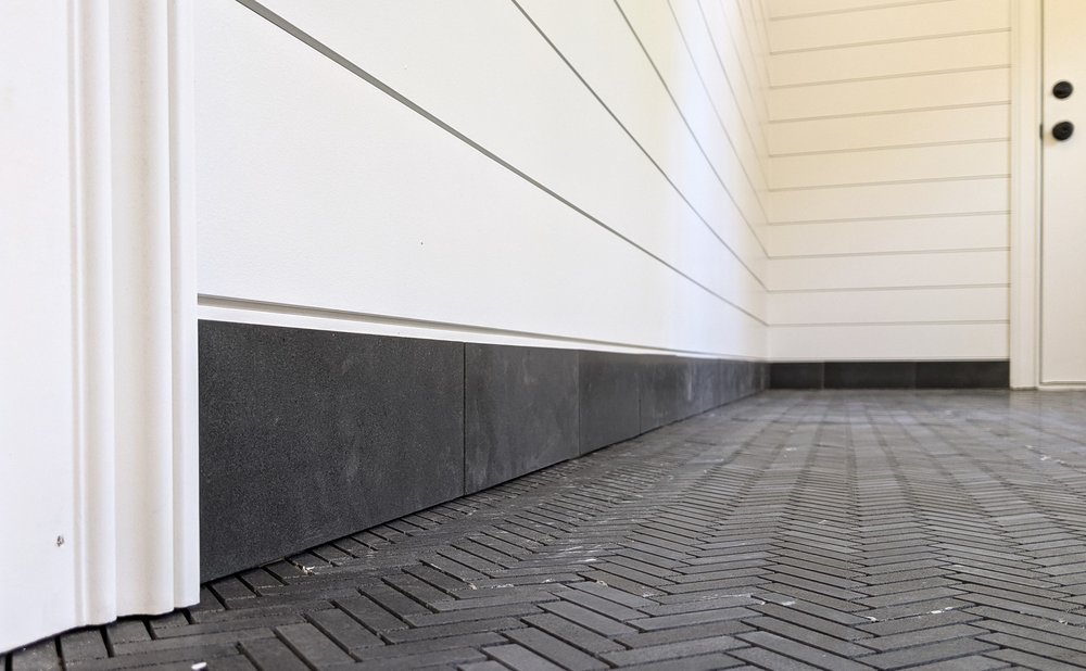 Mudroom floor in dark gray slate-look porcelain tile laid in a herringbone pattern
