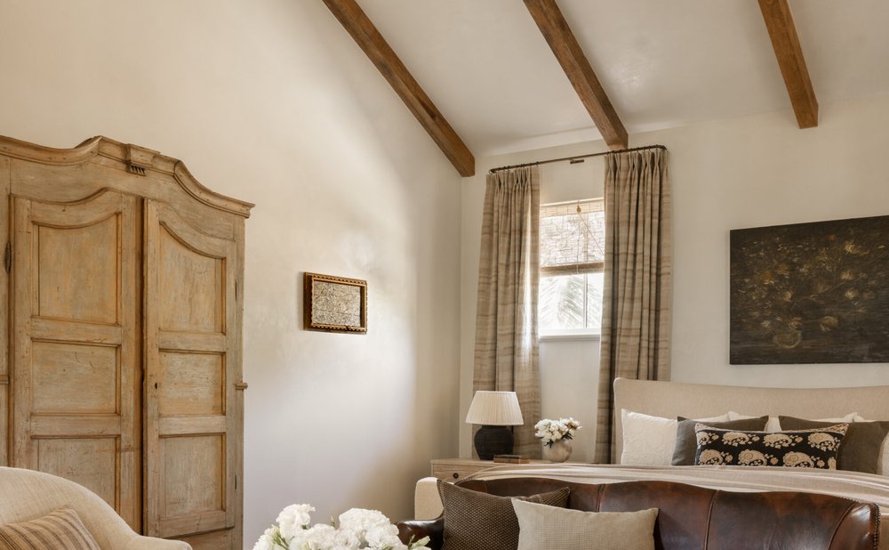 Stained wood beam ceiling over white living room walls