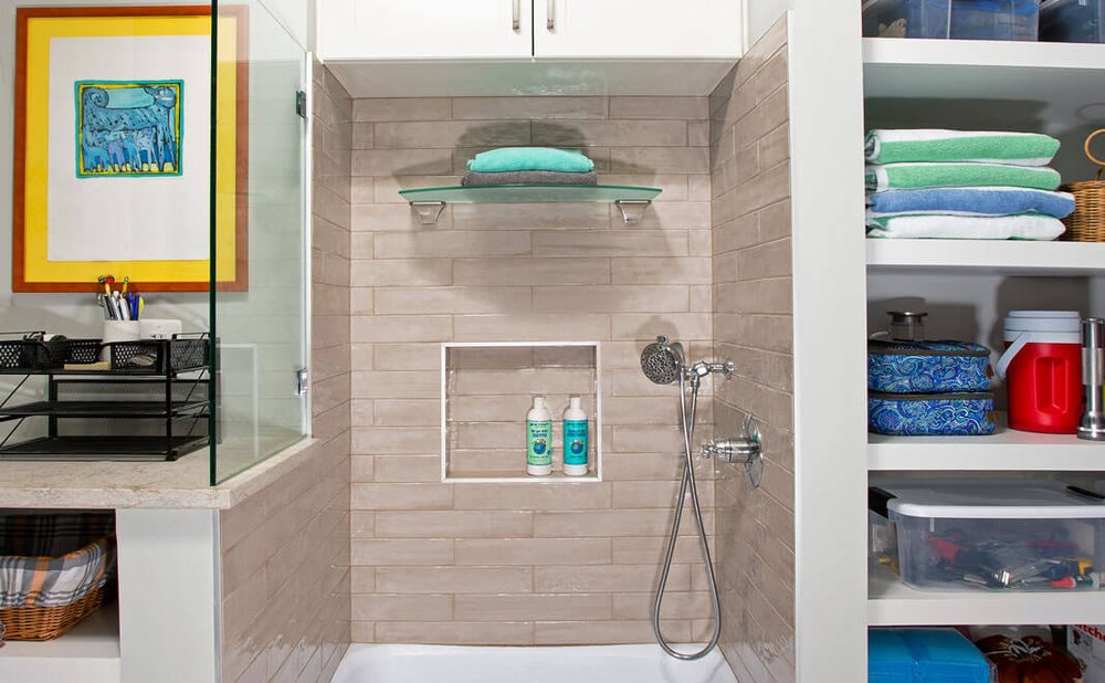 Mudroom pet-washing station with a raised tiled tub and handheld sprayer
