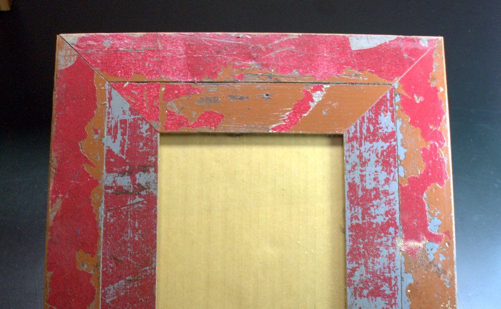 Picture frames made from leftover wood trim pieces on a shelf