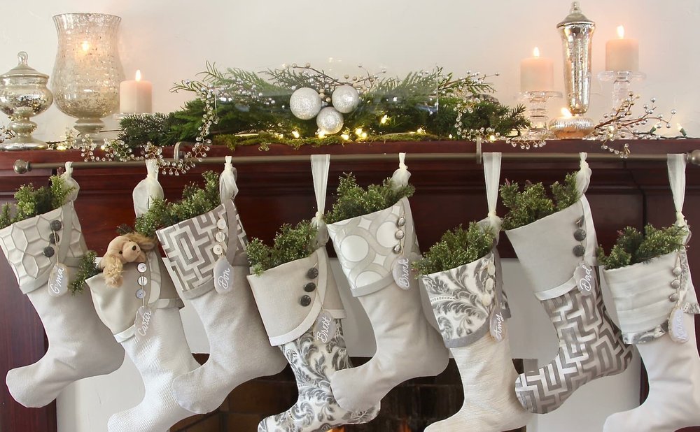 Christmas stockings hung from a rod with visible brackets along a dark wood mantel