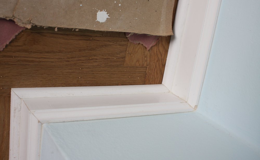 Bead of caulk sealing a gap between a baseboard and the floor