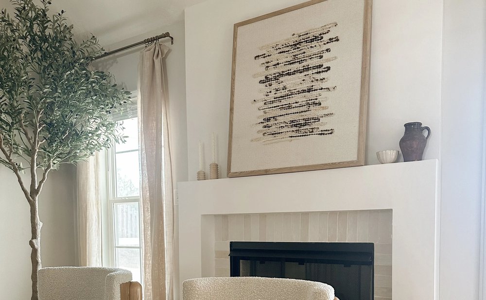 Minimalist mantel with one large abstract artwork above a clean white fireplace surround