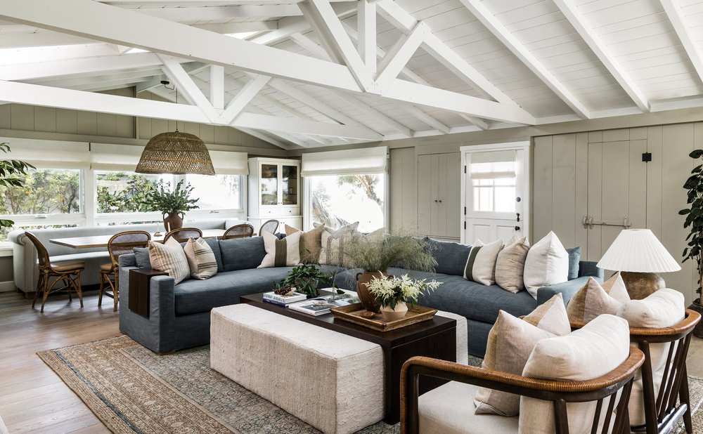 Coastal living room with soft blue sofas and a woven pendant