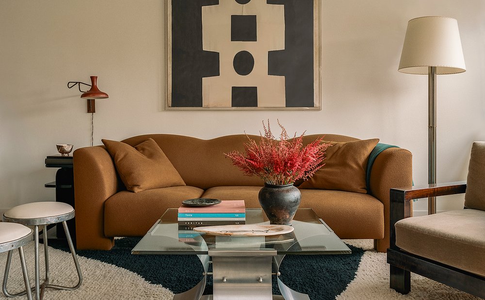 Compact living room with a cognac sofa, glass coffee table and floor lamp