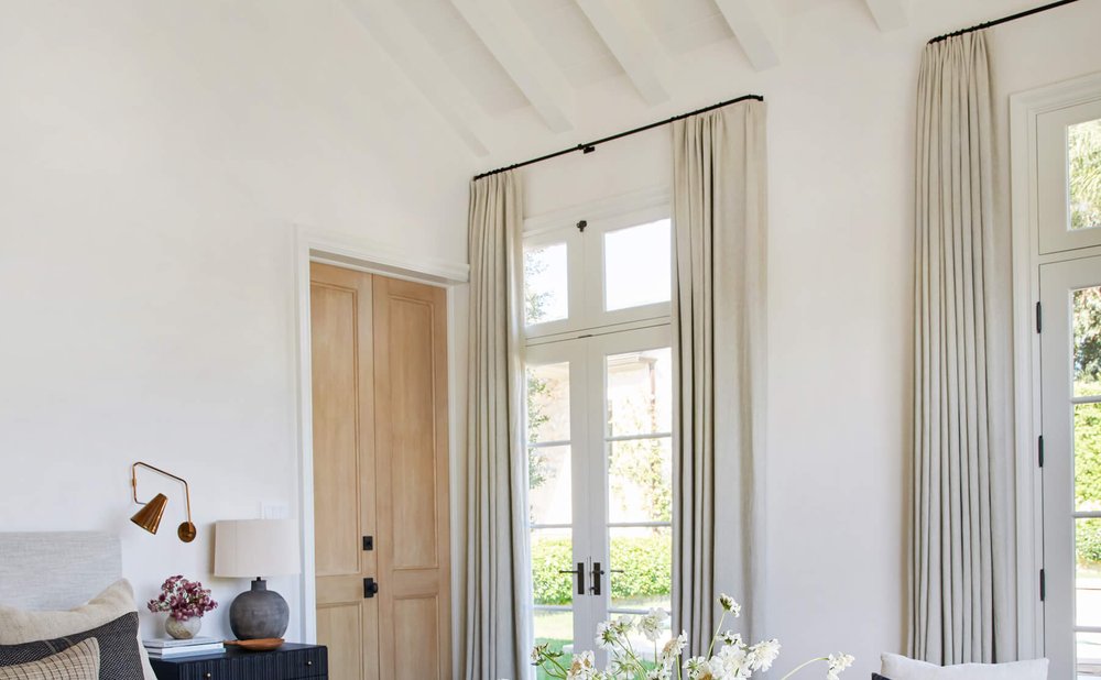 Floor-to-ceiling linen curtains framing tall windows