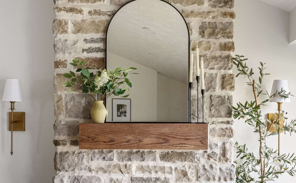 Stacked stone fireplace with natural textures and a wood mantel