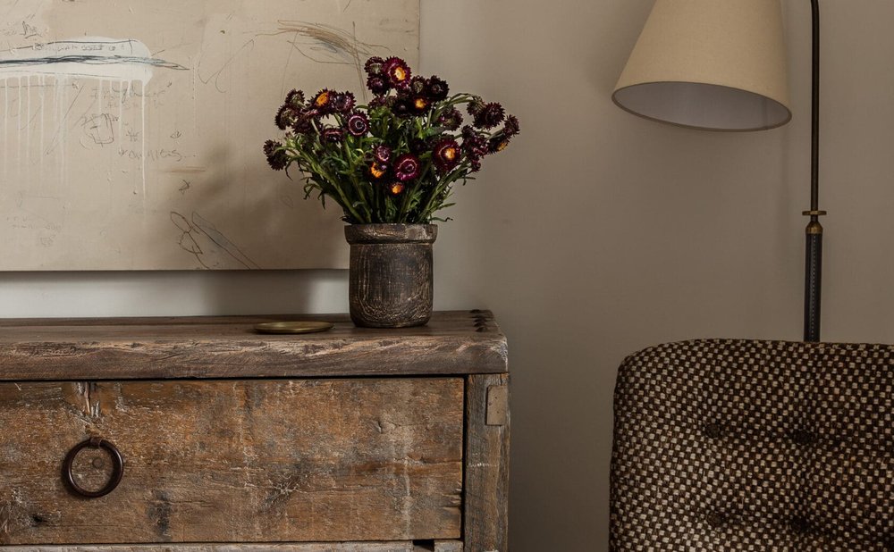 Reading corner with a tufted armchair, floor lamp and rustic side table
