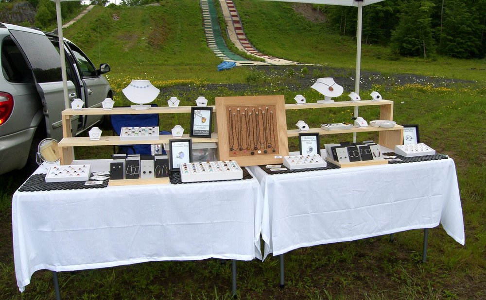 Craft fair table with scrap wood projects that sell, like signs and coasters