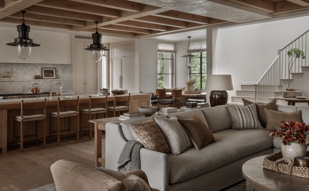 Open-concept living room with a rug-anchored seating zone and kitchen beyond