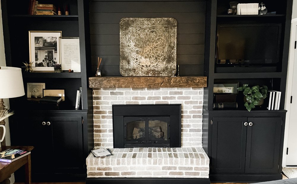 Built-in bookshelves flanking a fireplace with styled books and decor